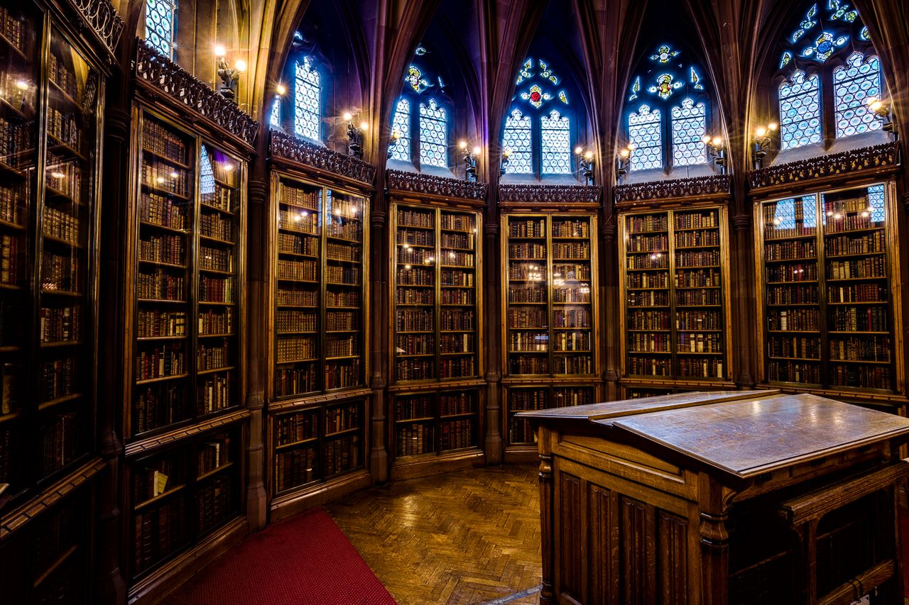 Intricate gothic architecture in a historic library room filled with bookshelves in England.