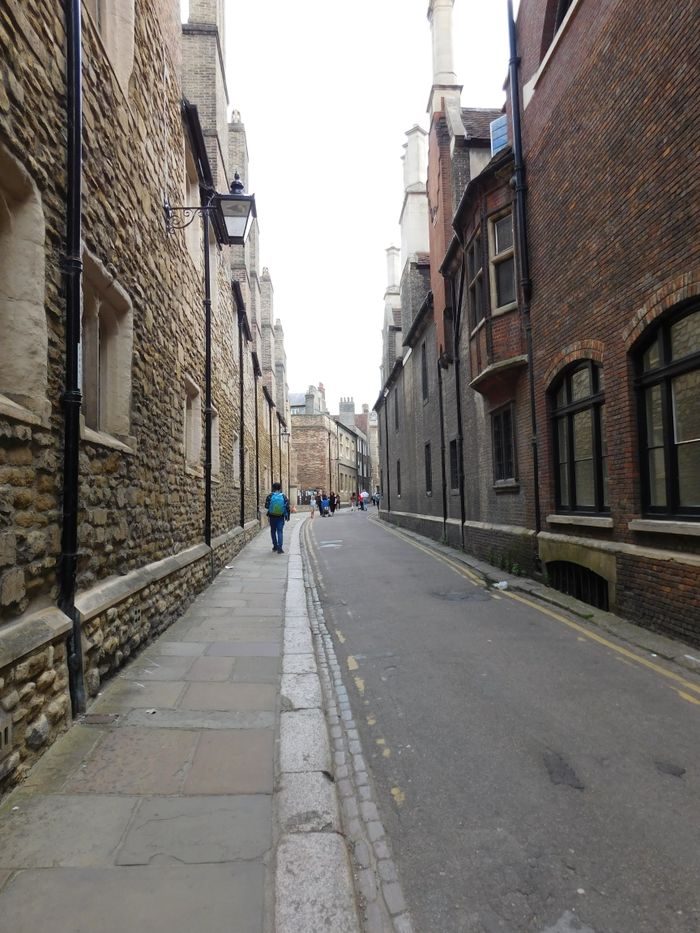 A picturesque alleyway with vintage architecture in Oxford, England, during a cloudy day.